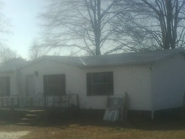 New metal roof on a white painted brick home on a foggy morning in Creston